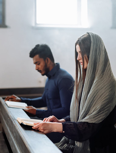 a man and woman are reading the bible